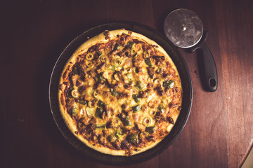 Pizza Pan take from top view with dark brown wood and cutter