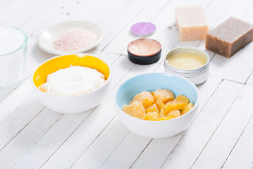 bath salts, beeswax , makeup base, powder compact, soaps and cosmetic creams on white wooden background