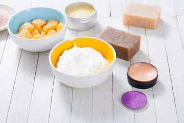 bath salts, beeswax , makeup base, powder compact, soaps and cosmetic creams on white wooden background