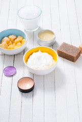 bath salts, beeswax , makeup base, powder compact, soaps and cosmetic creams on white wooden background