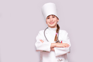 Smiling little girl in medical uniform looking at camera isolated