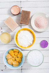 bath salts, beeswax , makeup base, powder compact, soaps and cosmetic creams on white wooden background