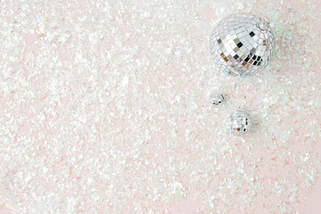 silver disco ball in pink glitter background