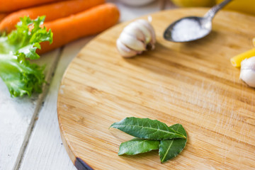 Bay leaves over wooden board