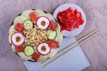Poke bowl trand. Raw fish, rice and halhy vegetables on wooden background