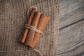 Cinnamon sticks on wooden background.