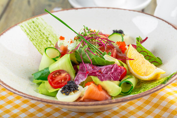 A delicious smoked salmon garden salad with smoked salmon, mixed baby greens