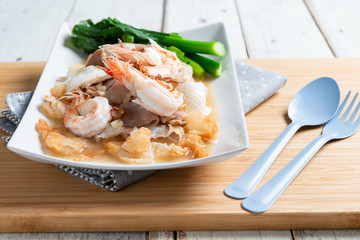 Fried noodles with pork , squid , shrimp and kale in gravy sauce