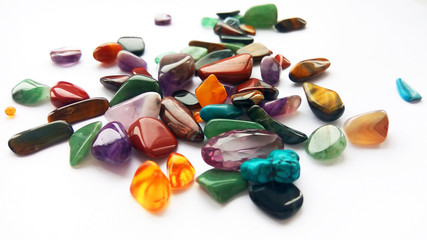 Assorted natural bright coloured semi precious gemstones and gems on white background