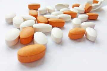 Spilling colorful pharmaceutical medicine pills, tablets and capsules in jar on white background. Pharmacy theme, health care, drug prescription for treatment medication and pharmaceutical medicament