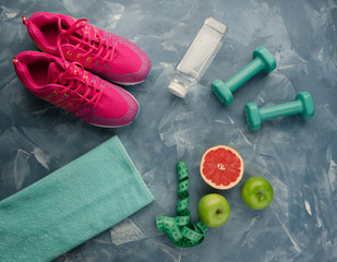 Sneakers dumbbells bottle of water apple pomelo and measure tape