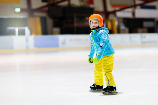 Child skating on indoor ice rink. Kids skate.