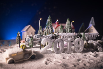 Miniature of winter scene with Christmas houses, train station, trees, covered in snow. Nights scene. New year or Christmas concept.