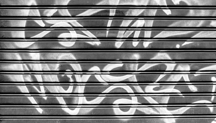 Black garage gate with graffiti