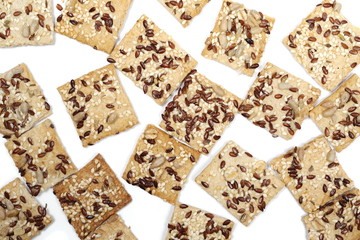 Salty integral flour crackers with linseed and sunflower seeds isolated on white background, top view