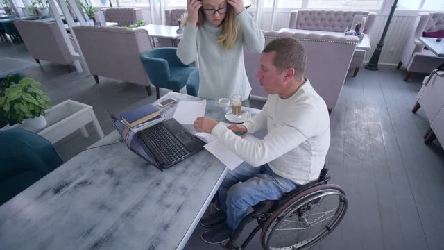 home education, successful disabled man in wheelchair with teacher female using modern computer technology during individual training in cafe