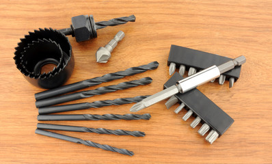 Hole saw and drill bit set on a wooden background