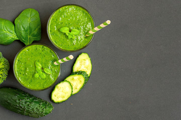 Two green smoothies with ingredients on dark background. Top view. With Copy space
