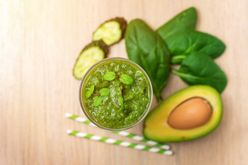 Spinach smoothies. Healthy green juice with ingredients on light wooden table. Top view