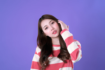 Long hair Korean woman looking and touch her hair, winter t-shirt clothing, purple background