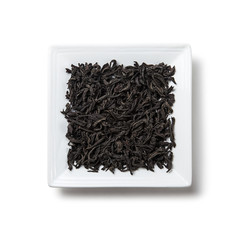 black tea dried on a white square plate on a white background with a shadow isolated