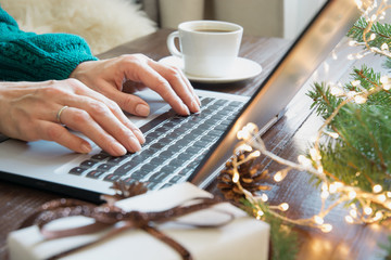 Christmas sales. Woman typing on laptop in home interior. Xmas concept. Planing holidays. Web...