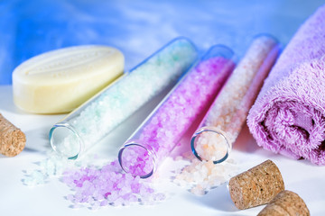 Various sea salt, cosmetic soap, towel on the bath tub background