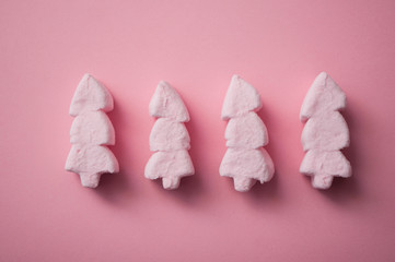 closeup of pink marshmallows in shaped fir on pink background