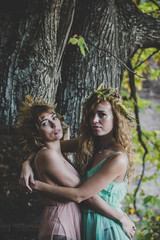 Two young women in an autumnal nature landscape background