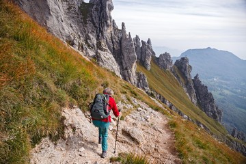 Naklejka premium A woman hiker, descends from a steep trail of the Southern Grigna.