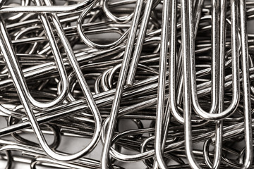 metallic paper clips on white background