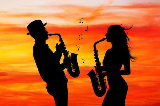 man and woman play the sax at sunset