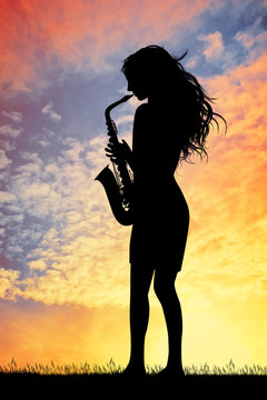 saxophonist woman at sunset