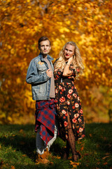 Photo of young couple standing in autumn forest