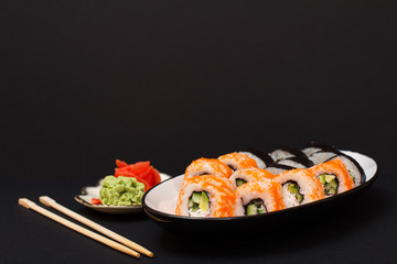 Uramaki California. Sushi rolls and plate with red pickled ginger and wasabi.