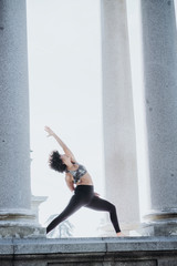 Afro woman practicing yoga in the city