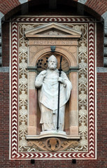 Obraz premium Statue of Sant'Ambrogio (Saint Ambrose) patron of the city of Milano (Milan). Detail of the clock tower of the Sforza Castle XV century (Castello Sforzesco). Lombardy, Italy