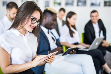 Diverse office people working on mobile phones, corporate employees holding smartphones at meeting. Serious multiracial businessmen and businesswomen using gadgets online apps for business, close up