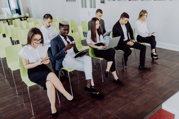 Businessmen and women in conference room on presentation of new product using devices.