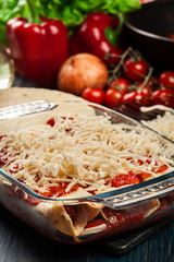 Traditional mexican enchiladas with chicken meat, spicy tomato sauce and cheese in heat resistant dish
