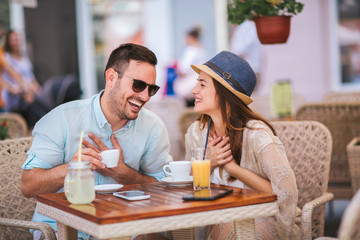 Beautiful loving couple sitting in a cafe enjoying in coffee and conversation, selective focus