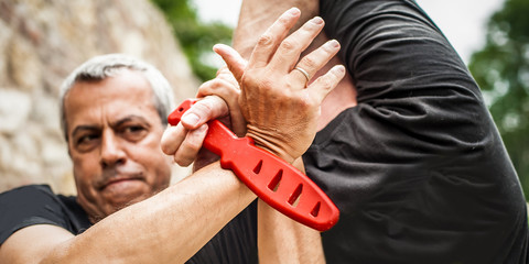 Knife disarm demonstration. Kapap instructor practice self defense knife threat disarming