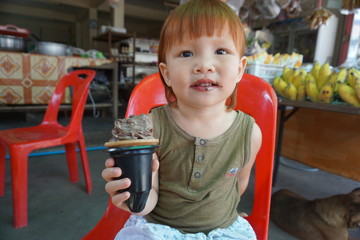 little girl eating an ice-cream,Red hair kid.