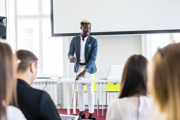 Fototapeta premium Confident Afro-American businessman discussing with his team in a presentation. Business conference. Business meeting.