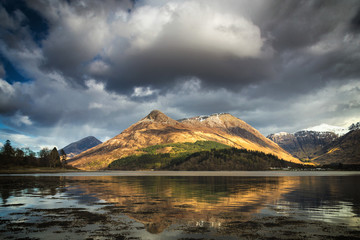 Reflections of Pap of Glencoe mountain in scottish Highlands.