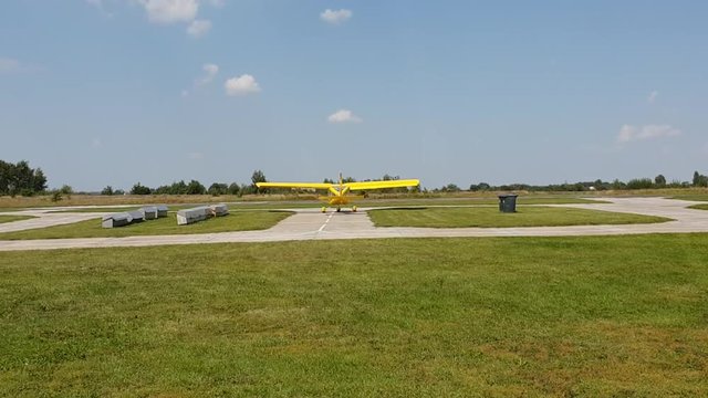 yellow plane with a propeller moves on the airfield preparing to take off