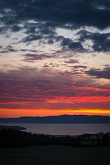 Sunset sky and distant city Ranheim in Norway. Distant sea view.