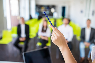 Close up of hands with pen on business seminar. Professional education, work meeting, presentation or coaching concept.