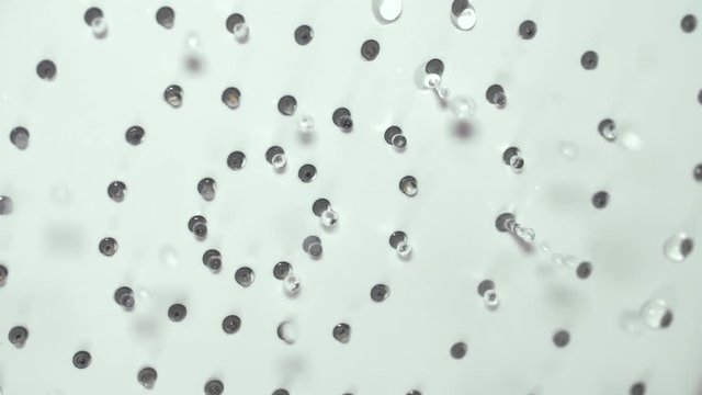 Drops of water slowly flowing from shower head, concept freshness and purity