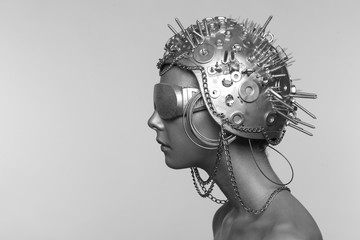 Futuristic woman in metal helmet and glasses